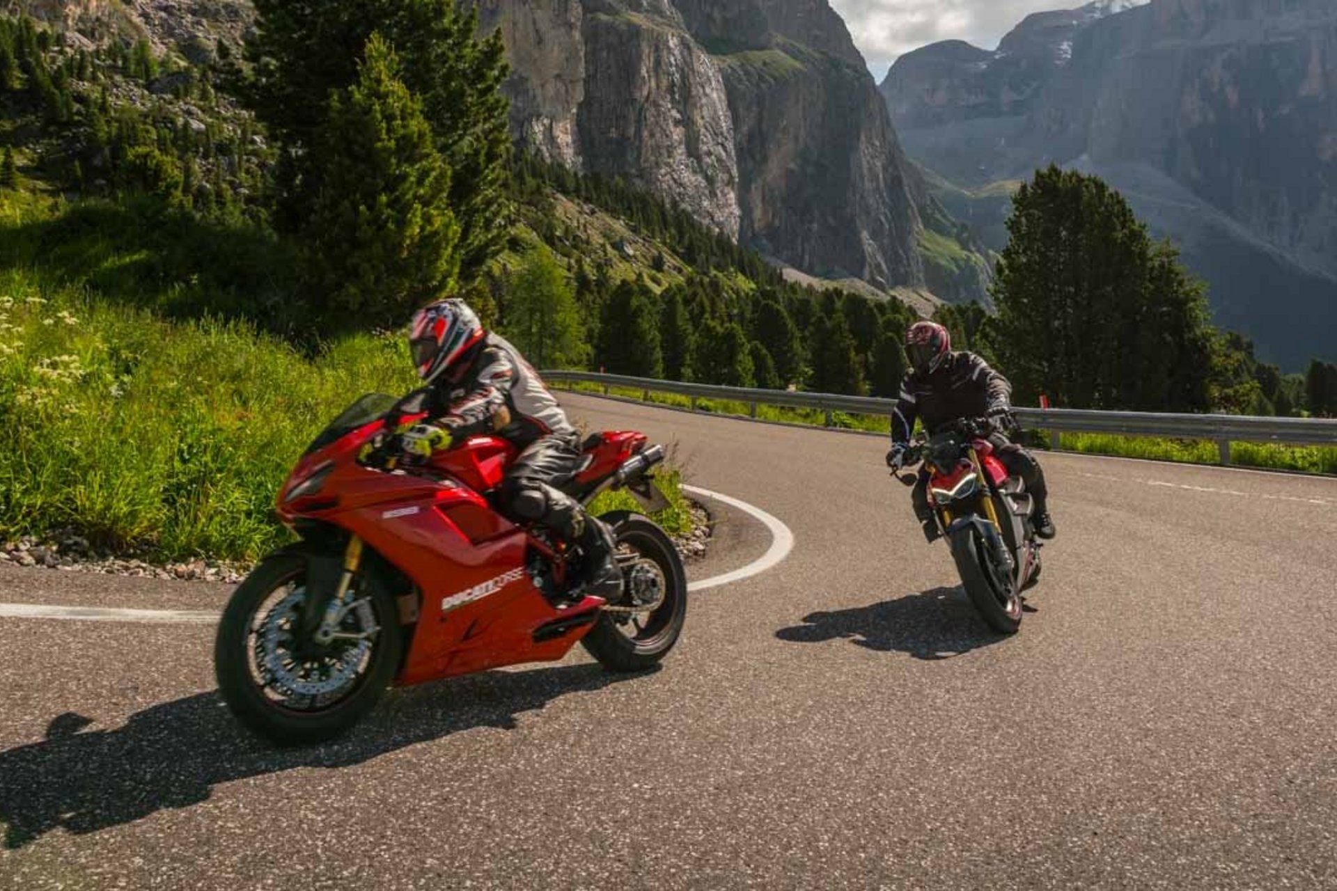 Motorradurlaub © Moppetfoto.de Zwei Motorradfahrer fahren durch kurvige Bergstraße bei sonnigem Wetter