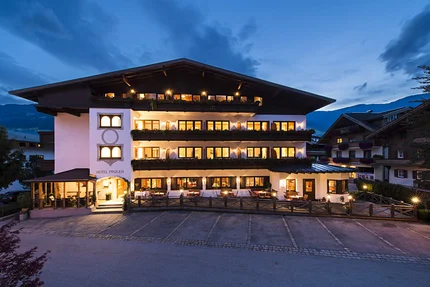 Hotel DER PINZGER © multi visual ART Illuminated hotel building at dusk in the mountains