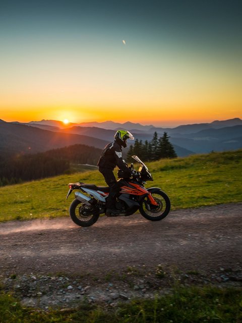 Motorradurlaub © Moppetfoto.de Motorradfahrer auf Schotterweg in den Bergen bei Sonnenuntergang