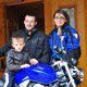 Motorradurlaub © Marisol s.n.c.di Pangrazzi Albino EC Familie mit Kind posiert vor blauem Honda Motorrad vor Holzhaus