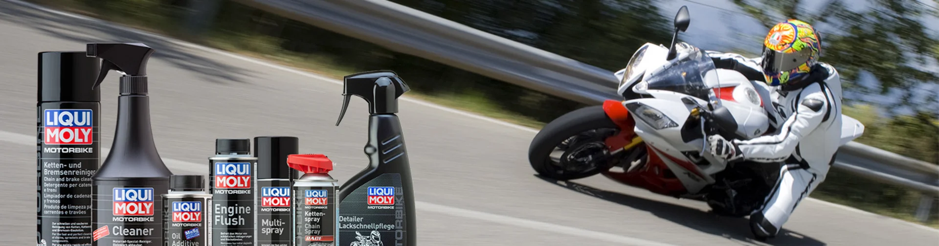 Motorradurlaub © Liqui Moly Motorrad fährt schnell auf kurviger Straße, davor Liqui Moly Motorradpflegeprodukte