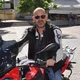 Motorradurlaub © Hotel Teutschhaus Mann mit Sonnenbrille auf rotem BMW Motorrad auf gepflastertem Platz