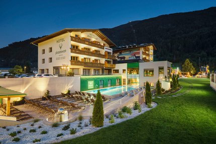 Hotel Jägerhof © Florian Scherl Hotel Jägerhof mit beleuchtetem Außenpool und Liegestühlen bei Nacht